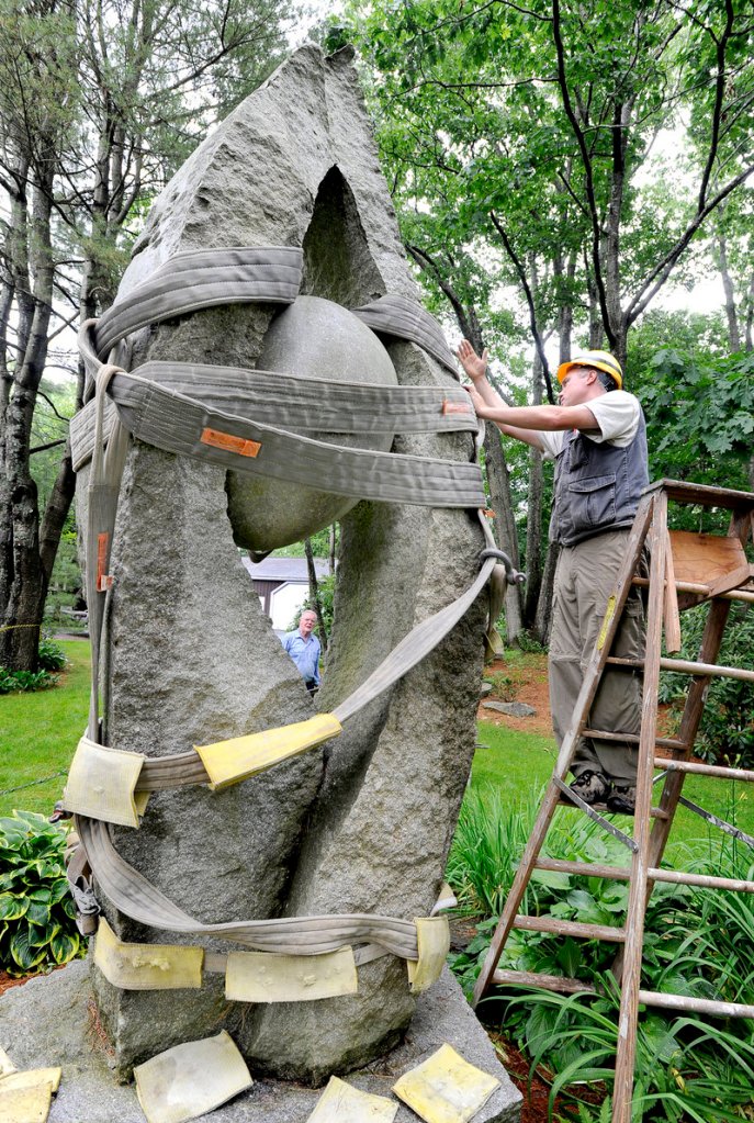 Jesse Salisbury prepares his granite sculpture “Tidal Moon” for its trip from the Yarmouth residence of William and Mary Louise Hamill to the Portland International Jetport where it will be displayed near the terminal’s baggage claim entrance.