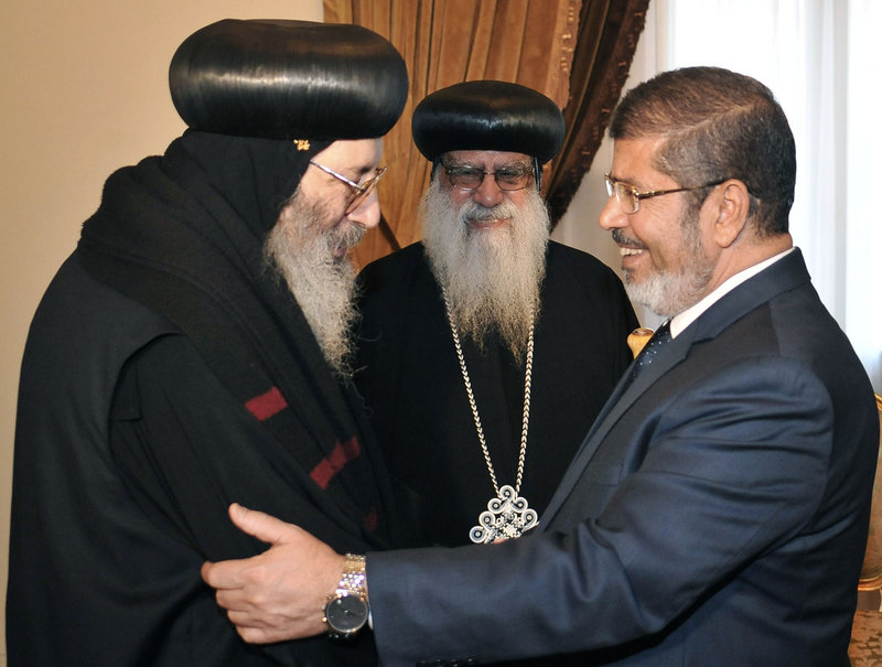 In this photo released by Egypt’s official news agency, President-elect Mohammed Morsi shakes hands with a representative from the Coptic community in Cairo on Tuesday. On Sunday, Morsi of the Muslim Brotherhood was declared Egypt’s first freely elected president in modern history.