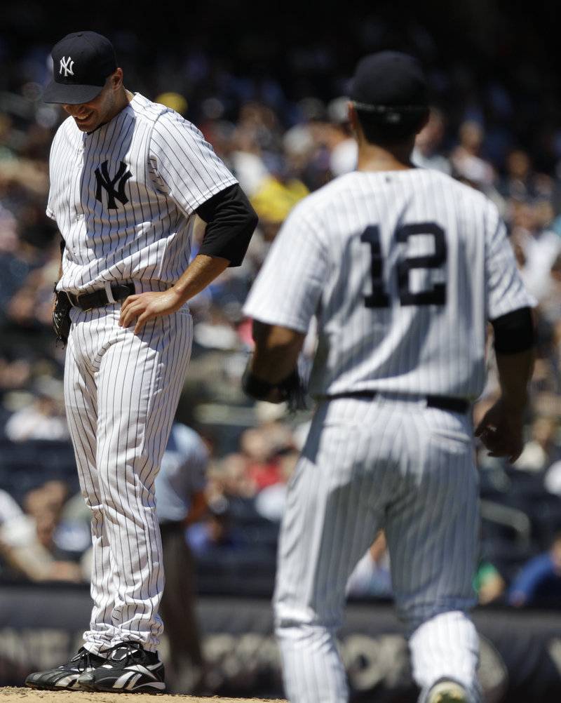 Andy Pettitte of the Yankees grimaces after taking a line drive that broke his left ankle Wednesday as first baseman Eric Chavez approaches. Pettitte may miss at least six weeks.