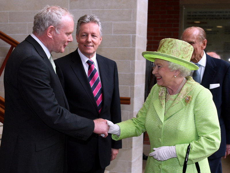Queen Elizabeth II shakes hands with Northern Ireland Deputy First Minister Martin McGuinness, as First Minister Peter Robinson looks on, Wednesday in Belfast.