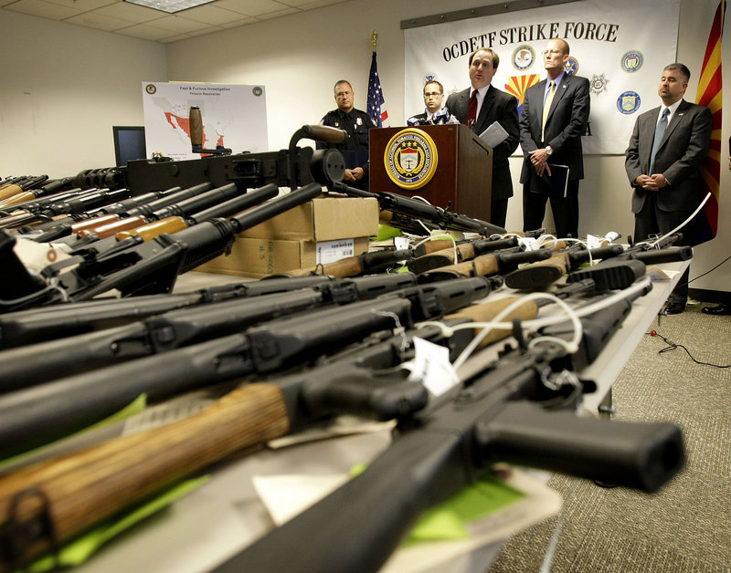 U.S. Attorney for Phoenix Dennis Burke speaks behind seized weapons in Phoenix last year. Burke was forced to resign amid the fallout from the Justice Department’s controversial “Fast and Furious” campaign to rein in gunrunning to Mexican drug cartels.