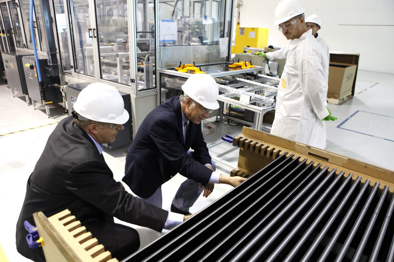 Secretary of the Interior Ken Salazar, right, examines solar electric panels at the Abound Solar manufacturing plant in Longmont, Colo., in 2009.