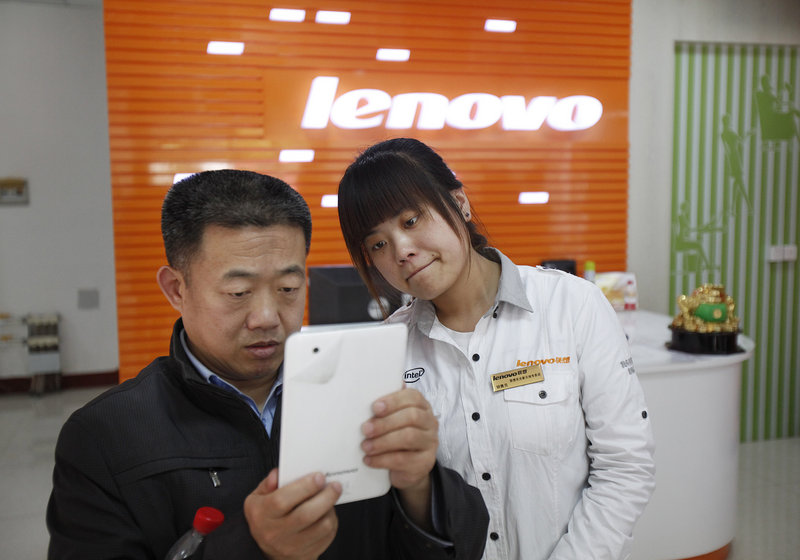 Lenovo sales associate Li Xiao Rui, right, helps Lei Qiu Lin in buying a LePad at a Lenovo store in Da Shan, China.