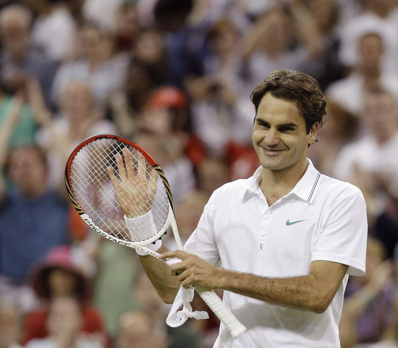 Roger Federer of Switzerland acknowledges cheers after winning his third-round match against Julien Benneteau of France at Wimbledon on Friday. Federer was two points away from losing six times against Benneteau.