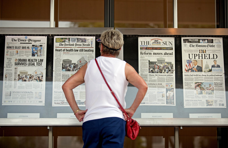 At the Newseum in Washington Friday, a visitor looks at a display of how newspapers from around the country, including The Portland Press Herald, presented the Supreme Court’s decision.