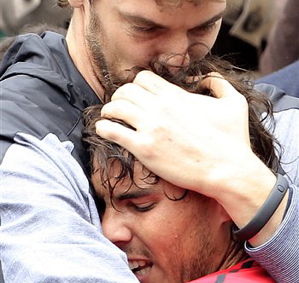Spanish NBA player Pau Gasol, top, hugs compatriot and friend Rafael Nadal after Nadal defeated Serbia's Novak Djokovic in their men's final match in the French Open in Paris today.