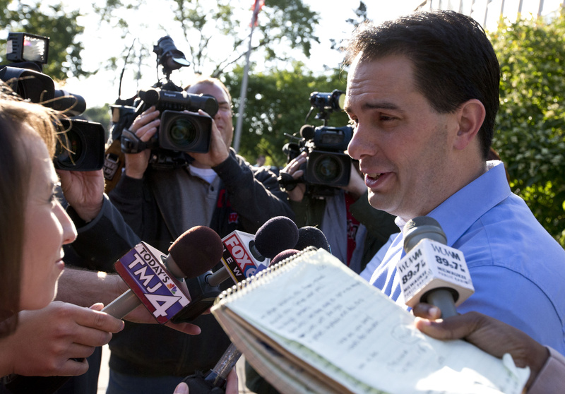 Wisconsin Republican Gov. Scott Walker talks to reporters after voting Tuesday in Wauwatosa, Wis. Walker survived the recall.