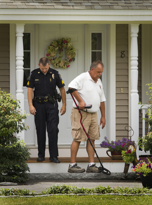 Gorham police Sgt. Michael Nault, left, and Officer Wayne Drown hunt for evidence Saturday at the scene of a shooting at 8 Mountview Drive.