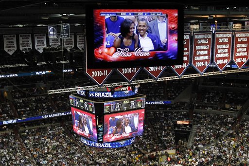 President Barack Obama and first lady Michelle Obama are seen on the in-house television monitors during the ''Kiss Cam" segment as they attend the U.S. men's Olympic basketball exhibition game between Team USA and Brazil in Washington on Monday.