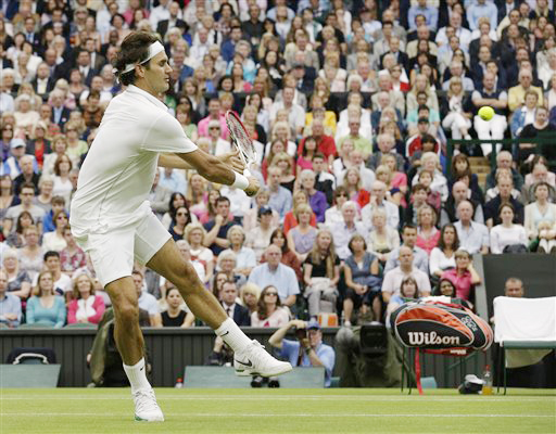 Roger Federer of Switzerland plays a shot to Novak Djokovic of Serbia during a semifinals match at the All England Lawn Tennis Championships at Wimbledon, England, today.