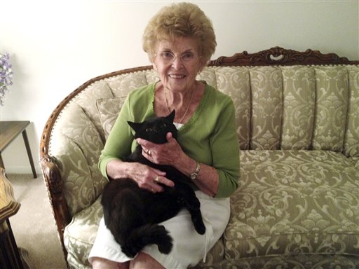 Barbara Oliphant and her cat Wollie at her home in Bedford, N.H. Animal rescue league officials said they don't know how the black cat walked about 6 miles in three days to find his way back home.