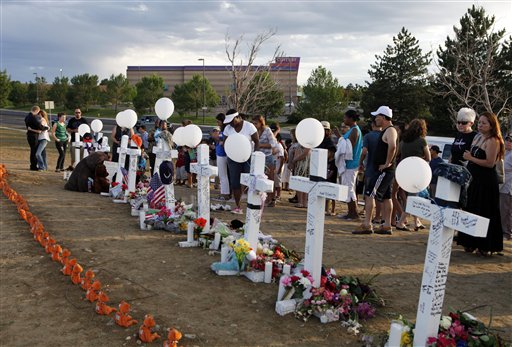 People visit a memorial for the victims in the shooting across the street from the Century 16 movie theater in Aurora, Colo., on Sunday.
