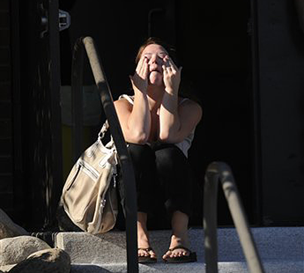 Amanda Medek, who is looking for her sister Micayla, sits outside Gateway High School, today in Aurora, Colo.