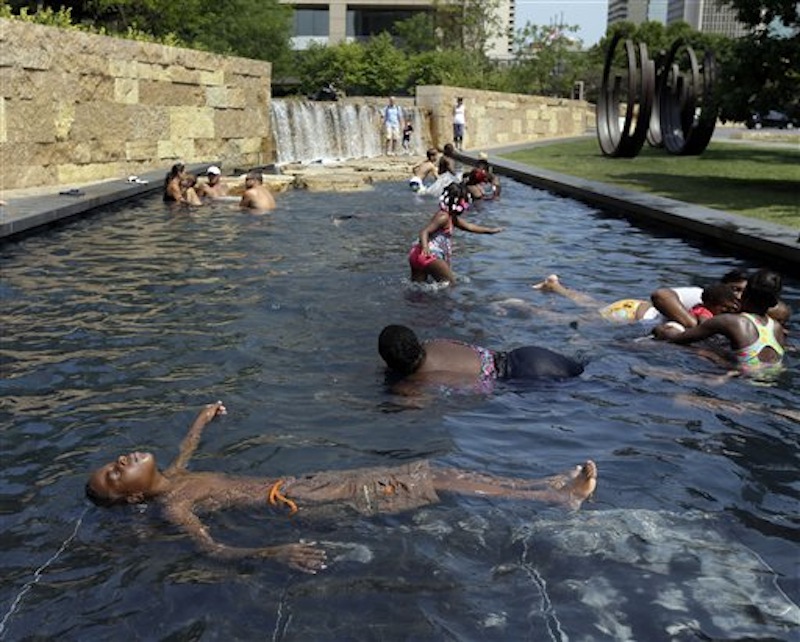 Mikel Welch, 9, floats on his back as he cools off in a fountain Friday, July 6, 2012, in St. Louis. Excessive-heat warnings remained in place Friday for all of Iowa, Indiana and Illinois as well as much of Wisconsin, Michigan, Missouri, Ohio and Kentucky. (AP Photo/Jeff Roberson)