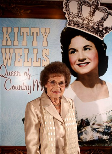 This Aug. 14, 2008 file photo originally released by the Country Music Hall of Fame and Museum shows music pioneer Kitty Wells at an exhibit honoring her career in Nashville, Tenn. Wells, the first female superstar of country music, has died at the age of 92. The singer's family says Wells died at her home Monday after complications from a stroke. Her recording of "It Wasn't God Who Made Honky Tonk Angels" in 1952 was the first No. 1 hit by a woman soloist on the country music charts. Other hits included "Making Believe" and a version of "I Can't Stop Loving You." (AP Photo/Country Music Hall of Fame and Museum, Donn Jones, file)