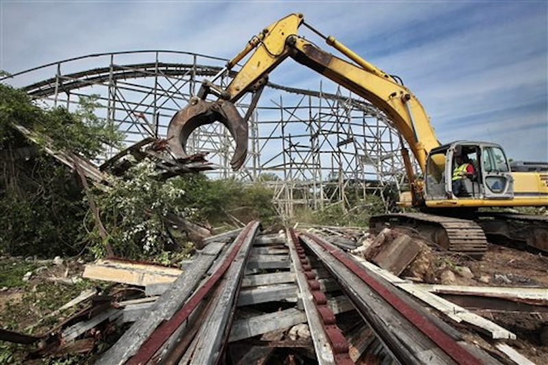 Earl Thibeault powers a machine as he demolishes the Comet roller coaster at the defunct Lincoln Park amusement park in Dartmouth, Mass., Wednesday July 11, 2012. The crumbling roller coaster is being cleared for a development that will include single-family homes, apartments and commercial space. (AP Photo/The Standard-Times, Peter Pereira) entertainment;coaster;roller coaster;wooden;fun;demolition