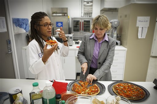 NASA's Advanced Food Technology Project manager Michele Perchonok, right, and Lockeed Martin Sr. Research Scientist Maya Cooper, try a pizza recipe in a test in a kitchen at Johnson Space Center in Houston on Tuesday.