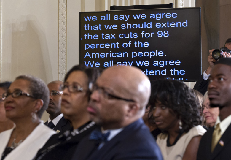 President Barack Obama's speech on extending tax cuts for the middle class scrolls past on a monitor as the audience listens in the East Room of the White House in Washington on Monday.