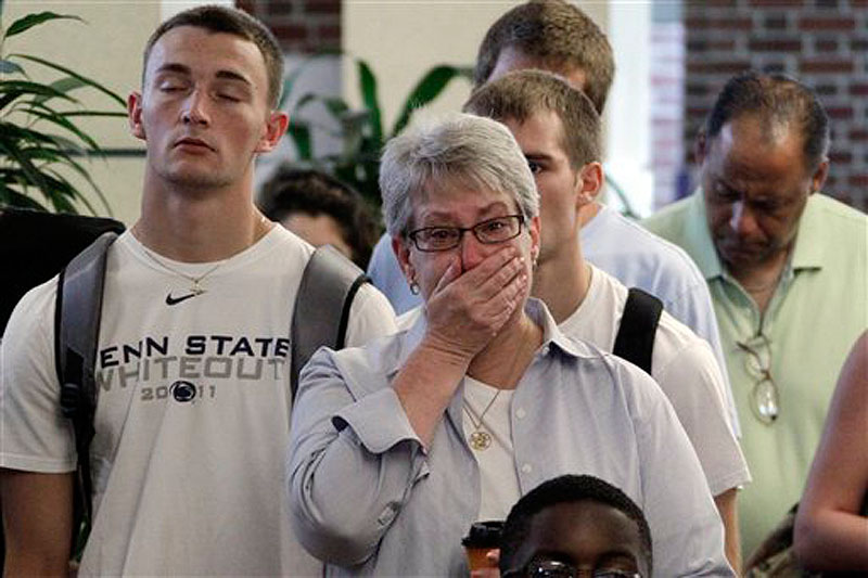 Susan DelPonte, center, of State College, Pa., reacts to a television in the HUB on the Penn State University main campus in State College as the NCAA sanctions against the Penn State University football program were announced Monday.