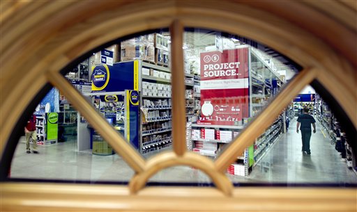 A shopper is seen through a window on display at a Lowe's store in Atlanta. Americans cut their spending at retail businesses for a third straight month, as a weak job market made consumers more cautious.
