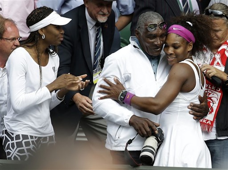 Serena Williams of the United States, right, embraces her father Richard Williams, center, as her sister Venus looks on, after she defeated Agnieszka Radwanska of Poland to win the women's final match at the All England Lawn Tennis Championships at Wimbledon, England, Saturday, July 7, 2012. (AP Photo/Alastair Grant)