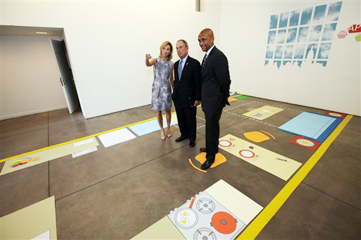 New York City Mayor Michael Bloomberg, center, stands with Amanda Burden, left, Department of City Planning Director, and Commissioner Mathew Wambua, Department of Housing Preservation and Development, in the kitchenette area of a full-scale mockup of a 300-square-foot apartment.