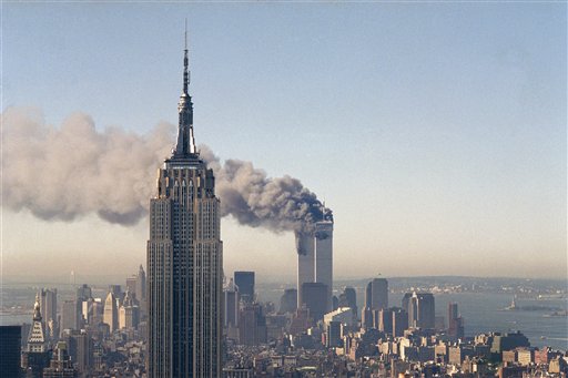 In this Sept. 11, 2001, file photo, the twin towers of the World Trade Center burn behind the Empire State Building in New York. The Sept. 11, 2001 terrorist attack is by far the most memorable moment shared by television viewers during the past 50 years, a study released on Wednesday, July 11, 2012, concluded. (AP Photo/Marty Lederhandler, File) 9/11 attacks building center empire state terrorist trade world xiconicx