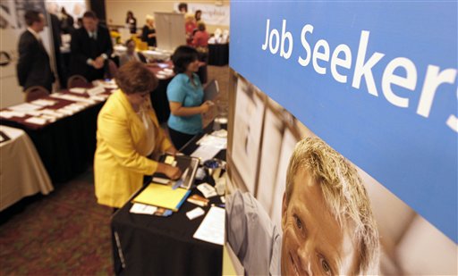 People walk by the recruiters at a jobs fair in the Pittsburgh suburb of Green Tree, Pa., in this Tuesday photo.