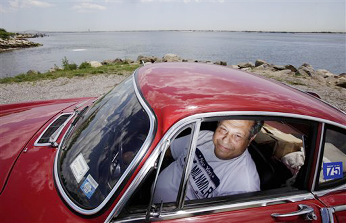 Irv Gordon poses for a picture in his Volvo P1800 in Babylon, N.Y., last week.