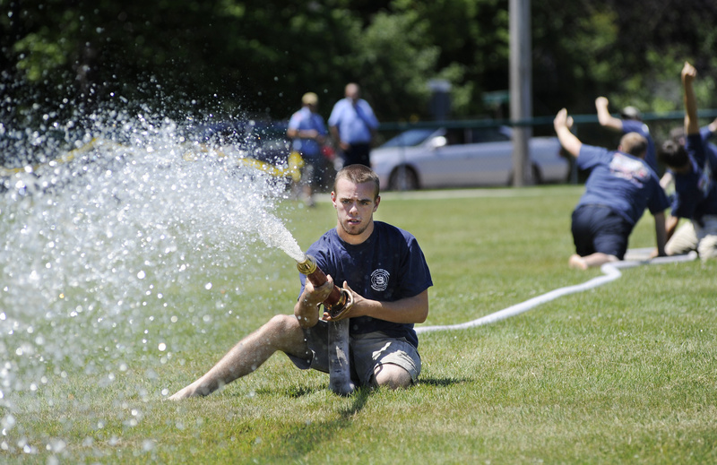 Matt Doe of the Kennebunk Fire Department aims his team’s hose at a target during the muster in York Beach on Sunday.