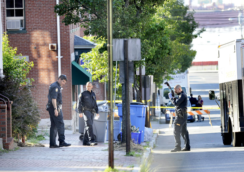 Portland police collect and photograph evidence at 105-107 India St., after an early-morning shooting in Portland.