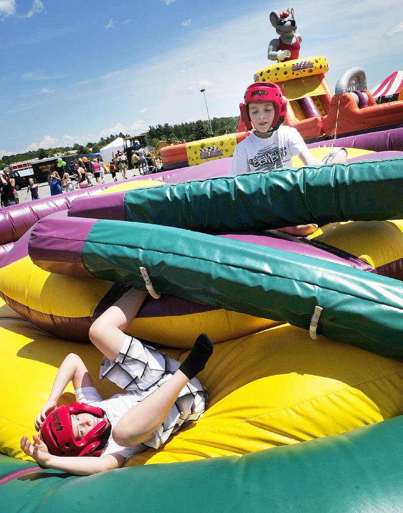 Dylan Perry, left, and Isaiah McCarthy, both 10 of Augusta, battle in the inflatable jousting pit during Saturday’s Whatever Family Festival Kid’s Day.