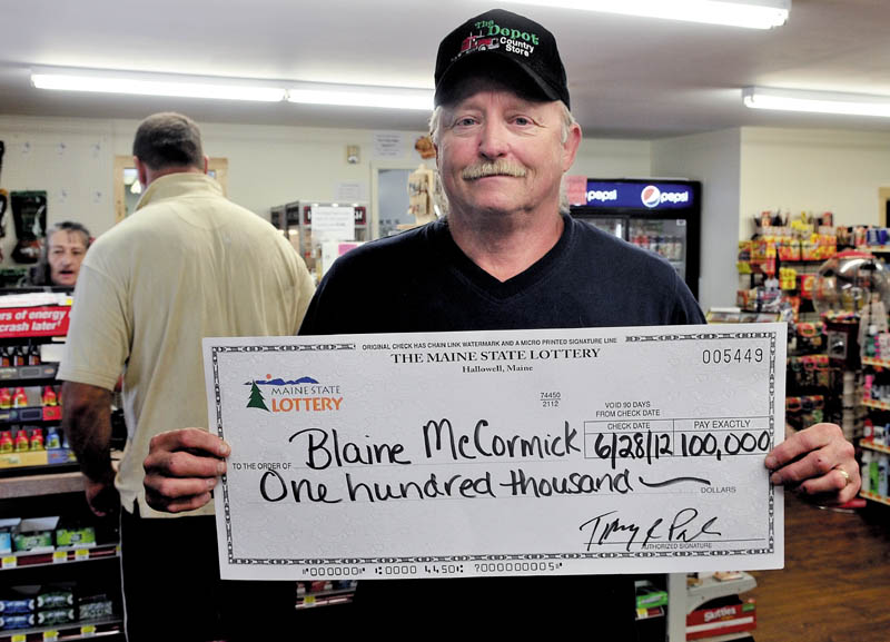 Blaine McCormick of Unity on Monday holds a mock check for the $100,000 he won from a state lottery ticket he purchased at the Depot Store in Unity where he works.