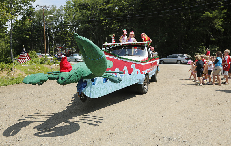 A truck decorated as a giant Christmas lobster is filled with children throwing candy and singing carols during the Chebeague Island Fourth of July parade.