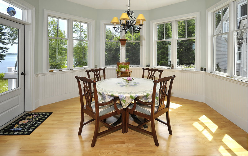 The six-sided room off the kitchen, with views of woods and water, serves as a breakfast room.