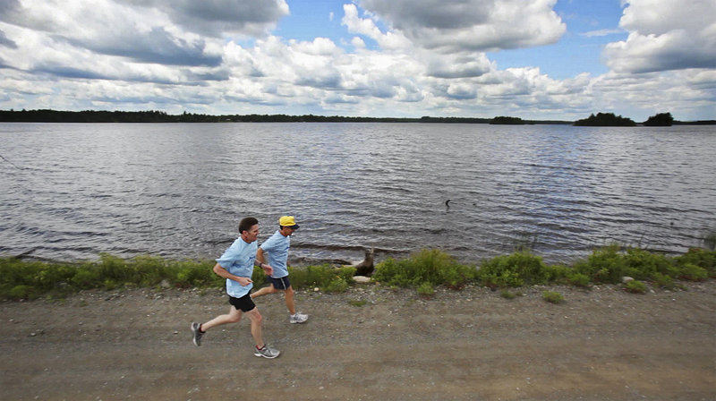 Early last month, Bob Bryant, left, and Dale Lolar run past the Grand Falls Flowage created by a dam on the St. Croix River. The two were participating in a 100-mile sacred run relay organized by members of the Passamaquoddy Tribe to bring attention to the plight of alewives, which have been prevented from reaching their spawning habitat because fishways had been closed along the river.