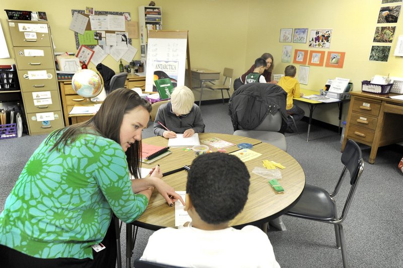 A teacher’s aide works with a student at Longfellow Elementary School in Portland. The opening of charter schools in Maine will siphon money from public schools, a reader says.