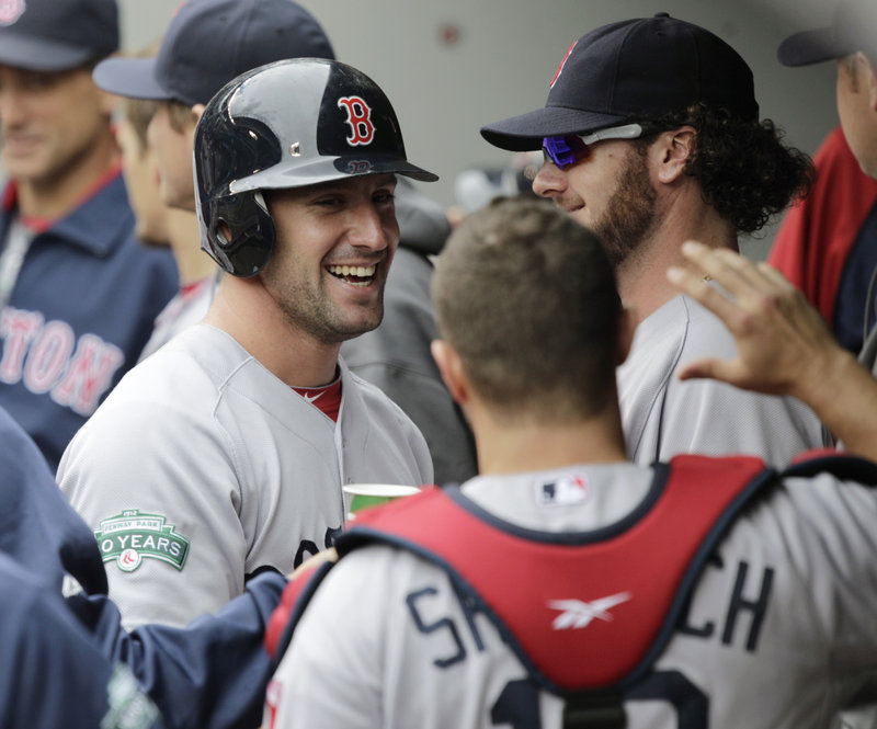 Ryan Kalish joins a happy Boston dugout after scoring the eventual winning run in the 10th inning on a sacrifice fly by David Ortiz at Seattle on Sunday.