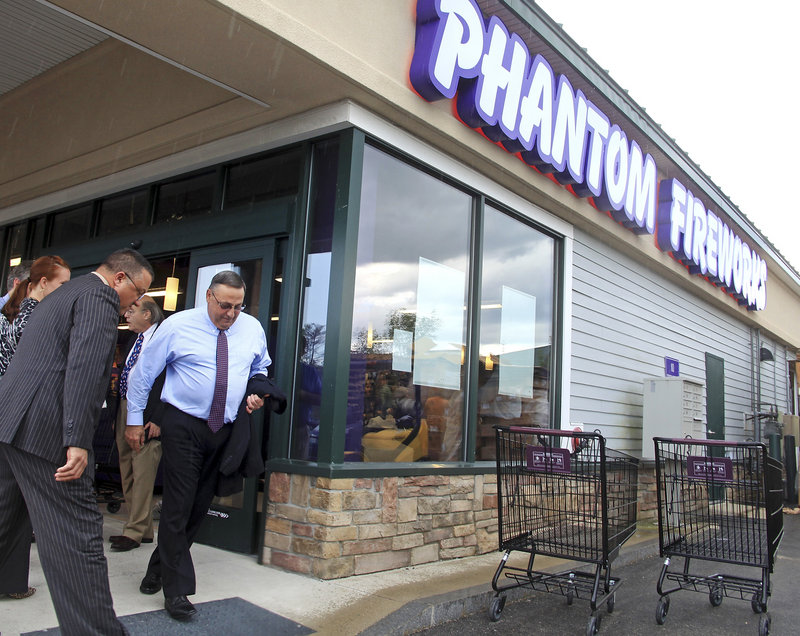 Gov. Paul LePage dashes for his car in a downpour Monday following a tour and news conference at Phantom Fireworks in Scarborough, a store that opened last month.