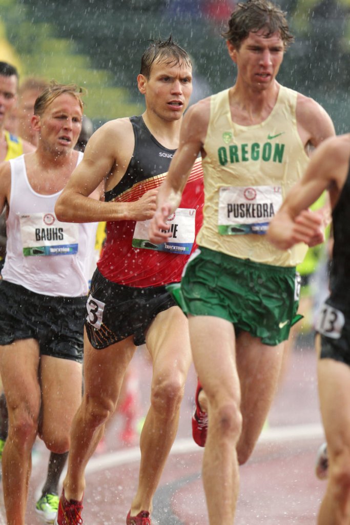 Ben True, in red and black, runs in the rain in the 10K at the Olympic trials in Eugene, Ore. He placed 12th in that race and 6th in the 5K finals.