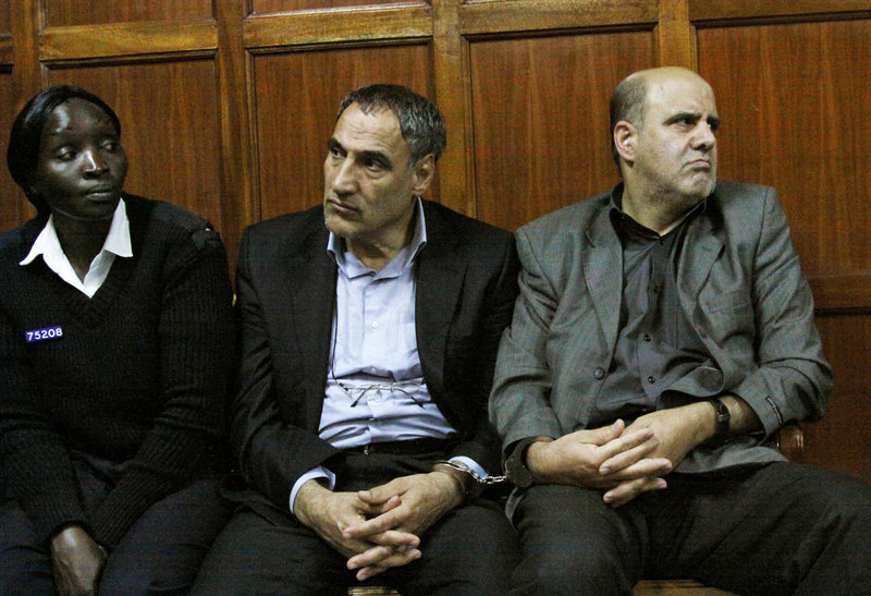 A Kenyan police officer, left, accompanies Iranian nationals Sayed Mansour Mousavi, center, and Ahmad Abolfathi Mohammad last week in the Nairobi magistrates court, where they faced charges related to the possession of explosives.