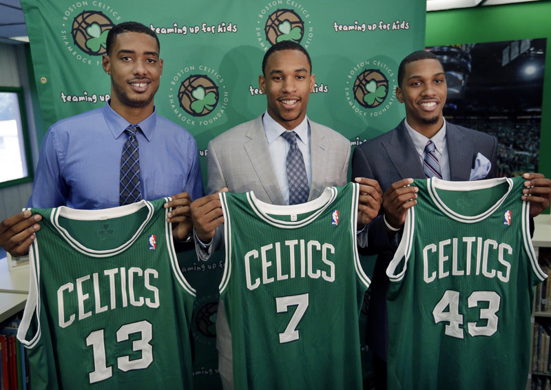 Boston Celtics 2012 draft picks, from left, center Fab Melo and forwards Jared Sullinger and Kris Joseph hold up their jerseys during an introductory NBA basketball news conference in Boston on Monday.