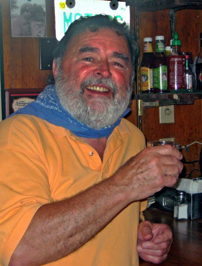 In this photo provided by the Florida Keys News Bureau, Richard Costello poses in his restaurant in Chatham, Mass., on Monday after learning he had won a Facebook-based Virtual "Papa" Hemingway Look-Alike Contest.