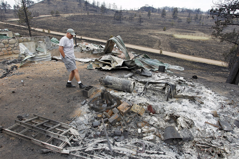 Martin Jiles looks over the ashes of his home that was destroyed by the High Park Fire near Livermore, Colo., on Monday. Residents have been allowed to return home as crews fully contained the 136-square-mile wildfire, which killed one resident and destroyed 259 houses.