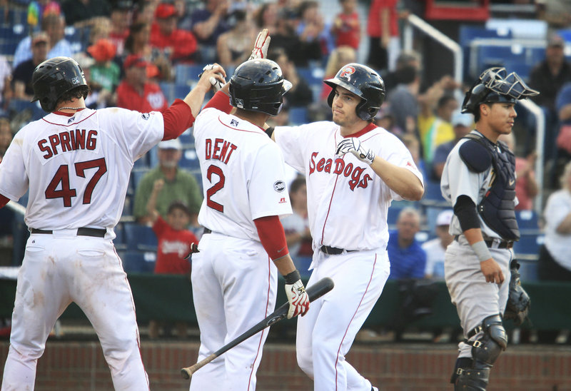 Sea Dog Drew Hedman, center, is congratulated by Matt Spring and Ryan Dent after his three-run home run in the bottom of the fourth at Hadlock Field on Monday. Portland, however, lost 12-4 in the first game of a doubleheader.