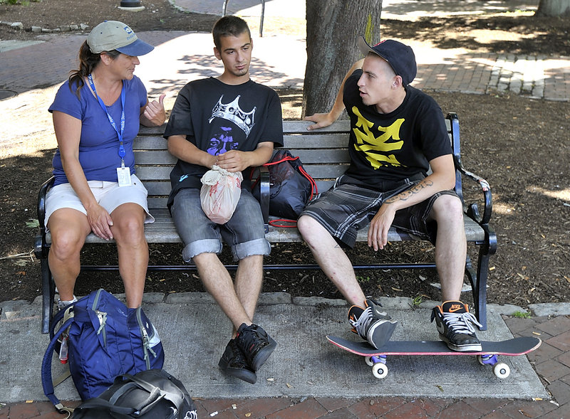 Peggy Lynch, an outreach team leader with the Preble Street Resource Center, talks with Joey Roest, left, 21, and Michael Tibbetts, 23, in Tommy’s Park this week about being homeless, finding jobs and assistance with getting into a residence.