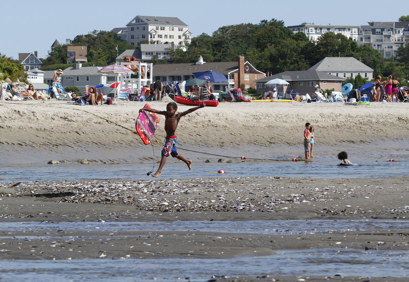 Visitors enjoy the sand and water at Riverside Beach in Ogunquit on Tuesday.