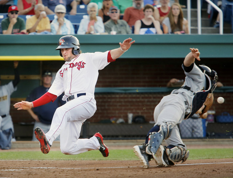 Bryce Brentz of the Portland Sea Dogs slides in to score Tuesday night as Trenton catcher Jeff Farnham lunges for the throw during the fourth inning at Hadlock Field. Trenton earned an 11-3 victory against the Sea Dogs, who will start a series tonight at New Hampshire.