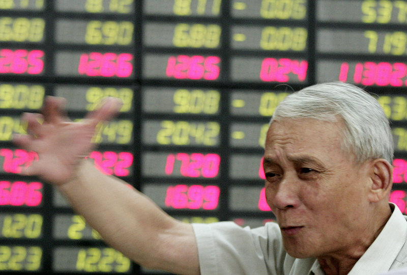 An investor gestures Wednesday in Shanghai, China. Global investors were cautious on a day Wall Street was closed. However, benchmark oil for August delivery was down 66 cents at $87 a barrel in electronic trading.