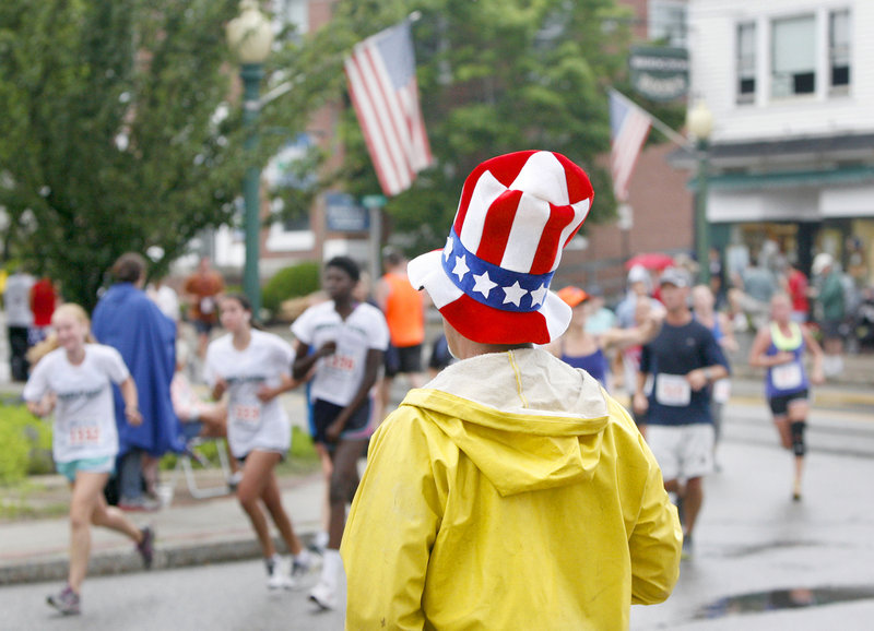Bill Farrell of Plymouth, Mass., watches runners turn onto Depot Street during the Four on the Fourth road race Wednesday in Bridgton. Farrell’s son-in-law was competing.